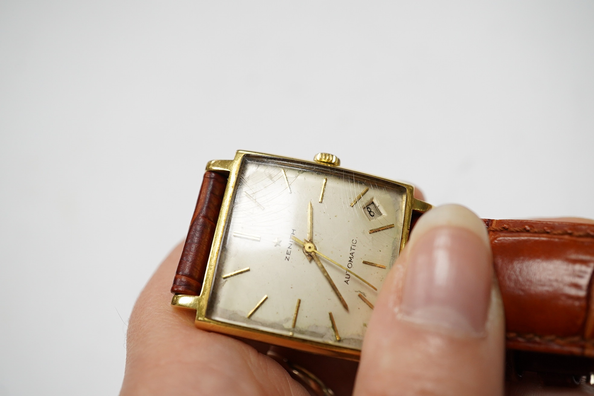 A gentleman's 18k Zenith Automatic square dial wrist watch, with baton numerals and date aperture, on an associated leather strap, case diameter 30mm. Condition - poor.